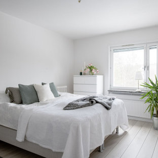 Idéer för mellanstora skandinaviska sovrum, med vita väggar, ljust trägolv och beiget golv
