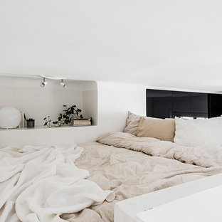 Aménagement d'une petit chambre mansardée ou avec mezzanine scandinave avec un mur blanc, un sol en bois clair et aucune cheminée.