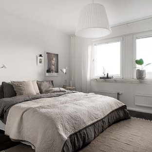 Bild på ett mellanstort minimalistiskt huvudsovrum, med vita väggar, mörkt trägolv och brunt golv