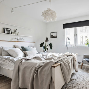 Idéer för ett minimalistiskt sovrum, med vita väggar, ljust trägolv och beiget golv
