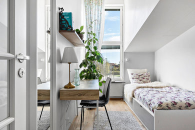 Foto på ett litet minimalistiskt sovrum, med vita väggar och mellanmörkt trägolv