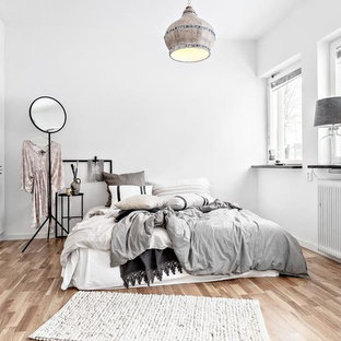 Idéer för mellanstora nordiska huvudsovrum, med vita väggar, beiget golv och ljust trägolv