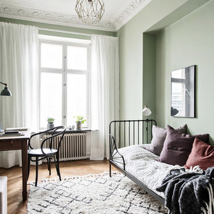 Idéer för att renovera ett mellanstort minimalistiskt gästrum, med gröna väggar, mellanmörkt trägolv och beiget golv