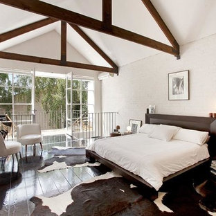 Foto de dormitorio tipo loft, urbano, grande, sin chimenea, con paredes blancas, suelo de madera oscura y marco de chimenea de metal