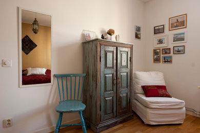 Ejemplo de dormitorio principal tropical de tamaño medio con paredes amarillas y suelo de madera pintada