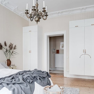 Idéer för skandinaviska sovrum, med beige väggar, ljust trägolv och beiget golv