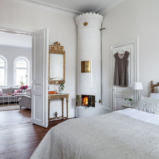 Foto de dormitorio principal, clásico, grande, con paredes blancas, suelo de madera oscura y estufa de leña