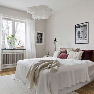 Idéer för ett mellanstort minimalistiskt sovrum, med vita väggar, mellanmörkt trägolv och beiget golv