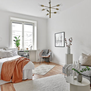 Idéer för ett mellanstort minimalistiskt sovrum, med vita väggar, mellanmörkt trägolv och beiget golv