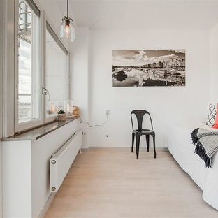 Imagen de habitación de invitados nórdica, pequeña, sin chimenea, con paredes blancas, suelo de madera clara, marco de chimenea de hormigón y suelo blanco