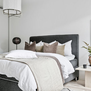 Nordisk inredning av ett sovloft, med vita väggar, ljust trägolv och beiget golv
