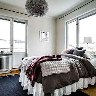 Idéer för att renovera ett mellanstort minimalistiskt huvudsovrum, med vita väggar, mellanmörkt trägolv och beiget golv
