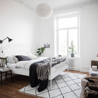 Inspiration för mellanstora skandinaviska sovrum, med vita väggar, brunt golv och mellanmörkt trägolv