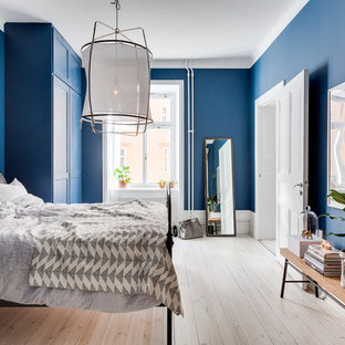 Ejemplo de dormitorio principal, tradicional renovado, grande, sin chimenea, con paredes azules y suelo de madera clara