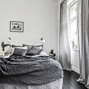 Inspiration för ett litet skandinaviskt sovrum, med vita väggar, målat trägolv och svart golv