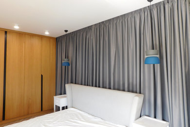 Imagen de dormitorio principal contemporáneo grande sin chimenea con paredes blancas, suelo laminado y suelo gris