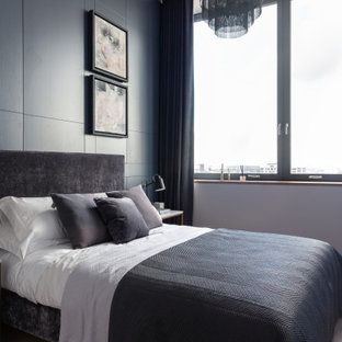 Contemporary bedroom in London with grey walls, medium hardwood flooring and brown floors.