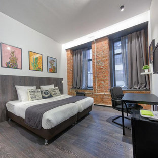 Ejemplo de habitación de invitados urbana, de tamaño medio, con paredes blancas, suelo laminado y suelo gris