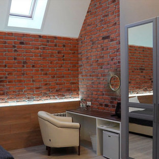 Foto de habitación de invitados industrial, de tamaño medio, sin chimenea, con paredes rojas, suelo de baldosas de porcelana, marco de chimenea de ladrillo y suelo beige
