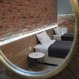 Ejemplo de habitación de invitados industrial, de tamaño medio, sin chimenea, con paredes rojas, suelo de baldosas de porcelana, marco de chimenea de ladrillo y suelo beige