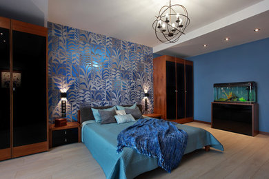 На фото: хозяйская спальня среднего размера в стиле фьюжн с синими стенами, полом из ламината и бежевым полом