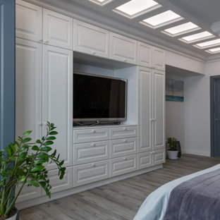Ejemplo de dormitorio principal y papel pintado, contemporáneo, de tamaño medio, papel pintado, sin chimenea, con paredes grises, suelo multicolor, papel pintado y suelo laminado