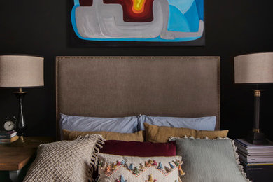 На фото: хозяйская спальня среднего размера в стиле лофт с черными стенами, полом из ламината и коричневым полом