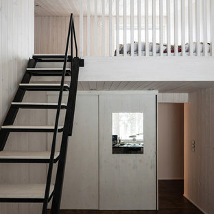 Foto de dormitorio tipo loft, actual, de tamaño medio, con paredes blancas, suelo de madera oscura y suelo negro