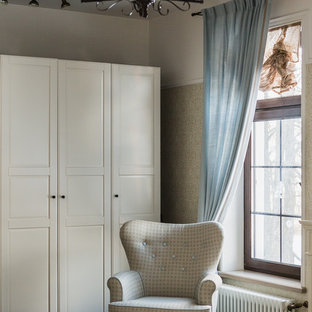 Ejemplo de dormitorio principal, tradicional, pequeño, con paredes blancas, suelo laminado, chimenea lineal, marco de chimenea de baldosas y/o azulejos y suelo marrón