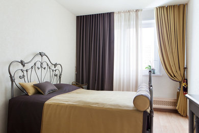 Foto de dormitorio principal tradicional pequeño con paredes beige, suelo de madera clara y suelo beige