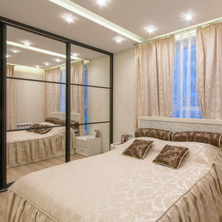 Diseño de dormitorio principal, clásico, de tamaño medio, con paredes blancas y suelo laminado
