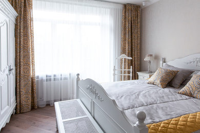 Ejemplo de dormitorio romántico con paredes beige y suelo de madera en tonos medios