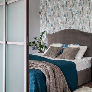 Стильный дизайн: хозяйская спальня среднего размера в современном стиле с серыми стенами, коричневым полом, обоями на стенах и акцентной стеной - последний тренд