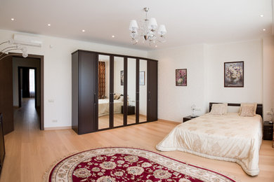 Diseño de dormitorio principal clásico renovado de tamaño medio sin chimenea con paredes beige, suelo laminado y suelo amarillo