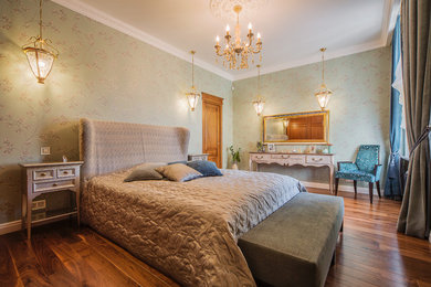 Diseño de dormitorio principal tradicional con paredes verdes y suelo de madera en tonos medios