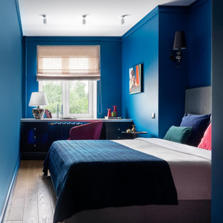 Diseño de dormitorio principal, pequeño, con paredes azules y suelo de madera en tonos medios