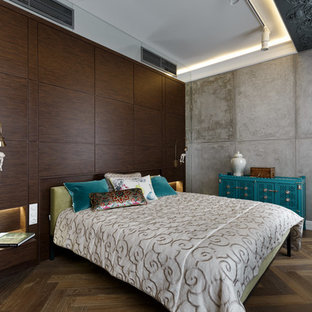 Imagen de dormitorio principal, ecléctico, con paredes grises, suelo de madera en tonos medios y suelo marrón