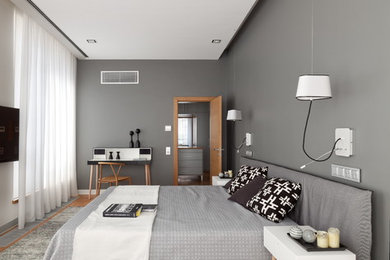 Стильный дизайн: большая хозяйская спальня в современном стиле с серыми стенами, паркетным полом среднего тона и коричневым полом без камина - последний тренд