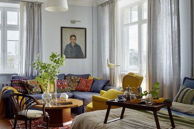 На фото: изолированная гостиная комната среднего размера в стиле фьюжн с паркетным полом среднего тона и серыми стенами с