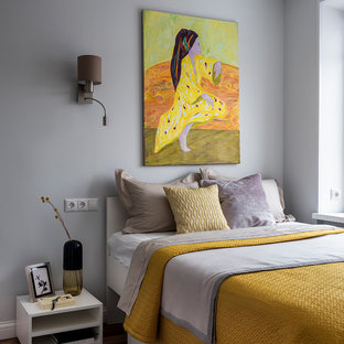 Diseño de dormitorio principal, nórdico, con paredes grises, suelo de madera en tonos medios y suelo marrón