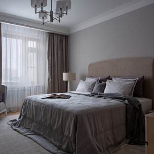 Mittelgroßes Klassisches Hauptschlafzimmer mit braunem Holzboden und grauer Wandfarbe in Moskau