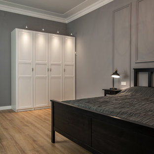 Diseño de dormitorio principal, contemporáneo, de tamaño medio, con paredes grises, suelo laminado y suelo amarillo