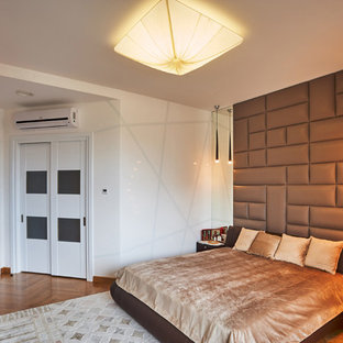 Imagen de dormitorio principal, actual, de tamaño medio, con paredes marrones, suelo de madera clara y suelo amarillo