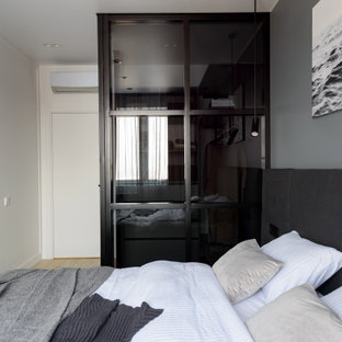 Foto de dormitorio principal, actual, de tamaño medio, con paredes grises y suelo laminado