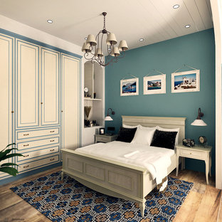 Imagen de dormitorio principal, mediterráneo, de tamaño medio, sin chimenea, con paredes azules, suelo de madera pintada y suelo marrón