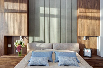Пример оригинального дизайна: хозяйская спальня среднего размера в современном стиле с серыми стенами, паркетным полом среднего тона и коричневым полом