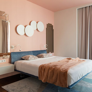 Modelo de dormitorio principal, contemporáneo, con suelo marrón, suelo de madera oscura y paredes rosas