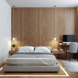 Imagen de dormitorio contemporáneo, de tamaño medio, sin chimenea, con suelo de madera en tonos medios y paredes marrones