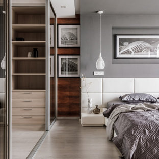 Mittelgroßes Modernes Hauptschlafzimmer mit grauer Wandfarbe, beigem Boden, Holzwänden und hellem Holzboden in Sonstige