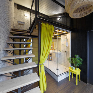 Diseño de dormitorio tipo loft, urbano, grande, con suelo de madera en tonos medios y paredes multicolor